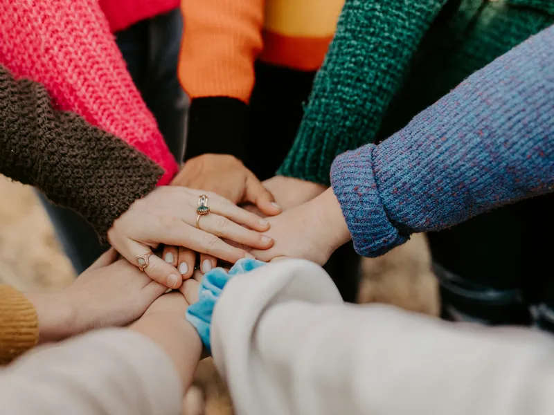 Un gruppo di persone unisce le mani, simbolo di comunità e sostegno reciproco