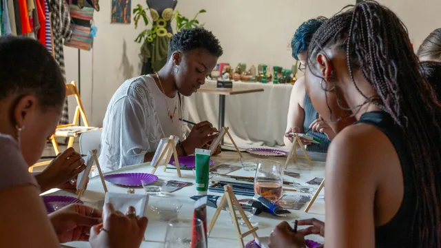 Un gruppo di persone dipinge insieme durante un laboratorio creativo