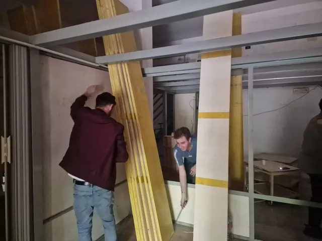 Il team coordina il montaggio dei pannelli divisori tra le strutture in cartongesso